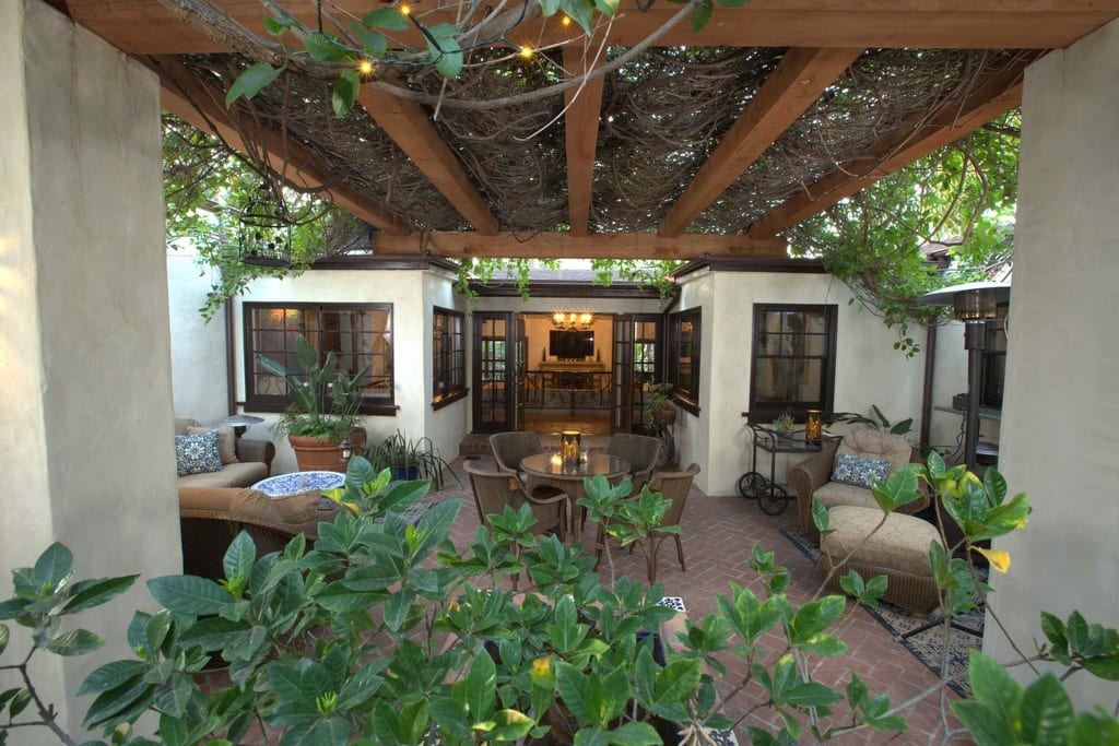 An outdoor patio with wooden beams and vines