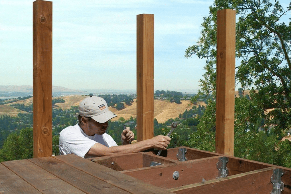 A man tightening bolts on a wooden deck